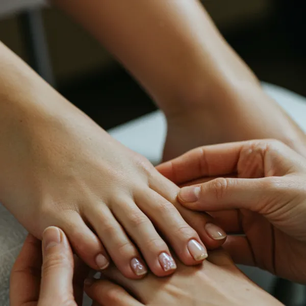imagen1 1 A high-resolution image featuring a close-up of a white woman receiving a luxurious manicure and pedicure in an elegant, modern nail salon. The focus is on her meticulously cared-for hands and feet, showcasing intricate nail art and a serene, ambient setting that reflects integrated care and beauty.